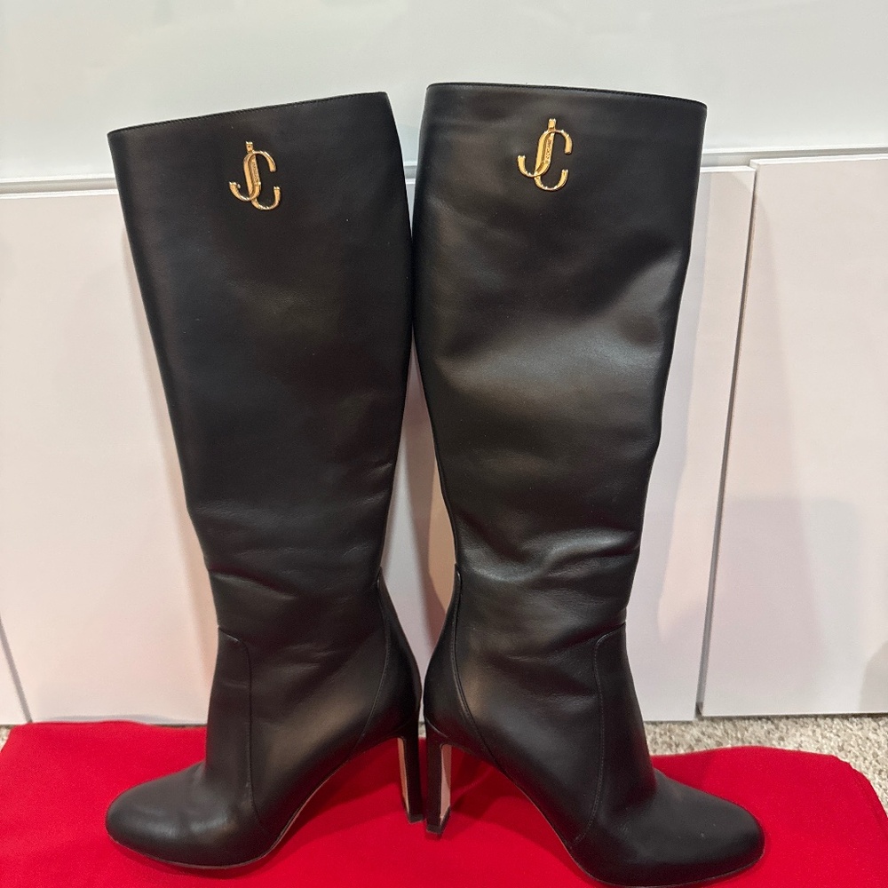 his is a Jimmy Choo knee-high leather stiletto boot with JC monogram hardware